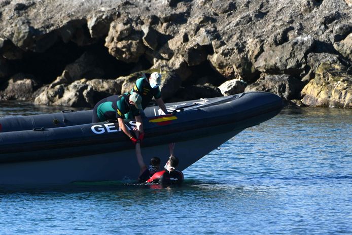 Elements of the Spanish Civil Guard take back two migrants from the sea.
