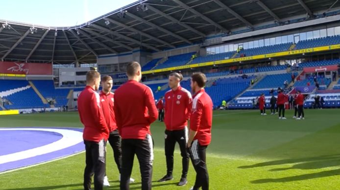 Wales players exploring the field.