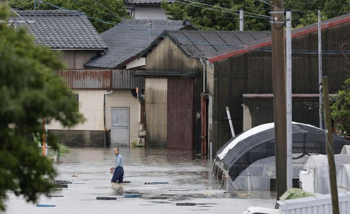 A man walks down a flooded street in Kurume, Fukuoka Prefecture, southern Japan.