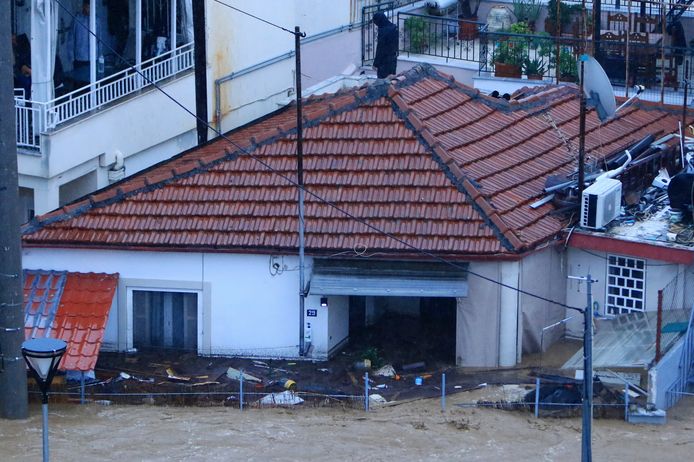 A man stands on the roof of his flooded house in Volos.