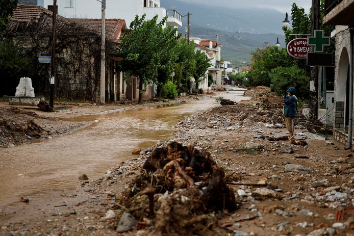 A woman looks at damage caused by mud in Agria, central Greece.