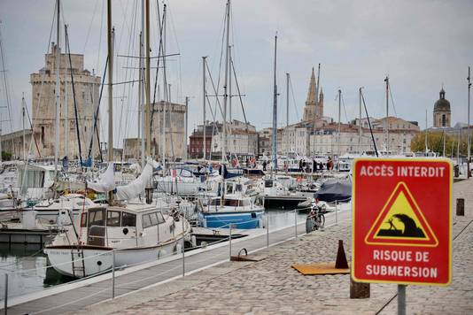 Signs in La Rochelle, France, warning of high waves on the pier.