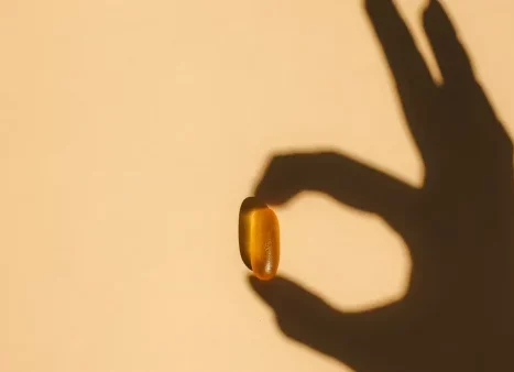 Schaduw hand houdt vitamine D pil vast