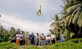 Oliver Bungold (first next to the flag), together with other Chagossians, raised the flag of Mauritius on one of the islands during last year's visit. 